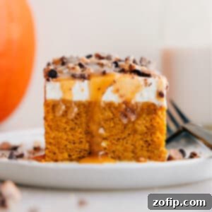 Spiced Pumpkin Poke Cake 2 The finished Pumpkin Poke Cake garnished with whipped cream, caramel, and toffee bits, presented beautifully for serving.