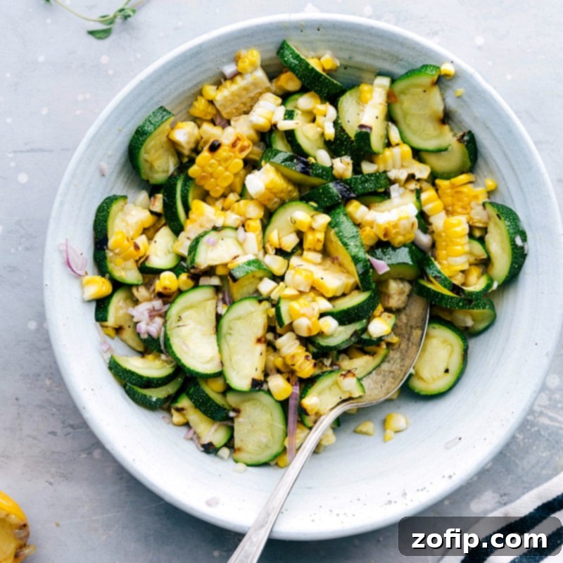 A bowl of grilled corn and zucchini salad, a flavorful side dish accompanying the greek chicken recipe, highlighting the vibrant colors and delicious ingredients.