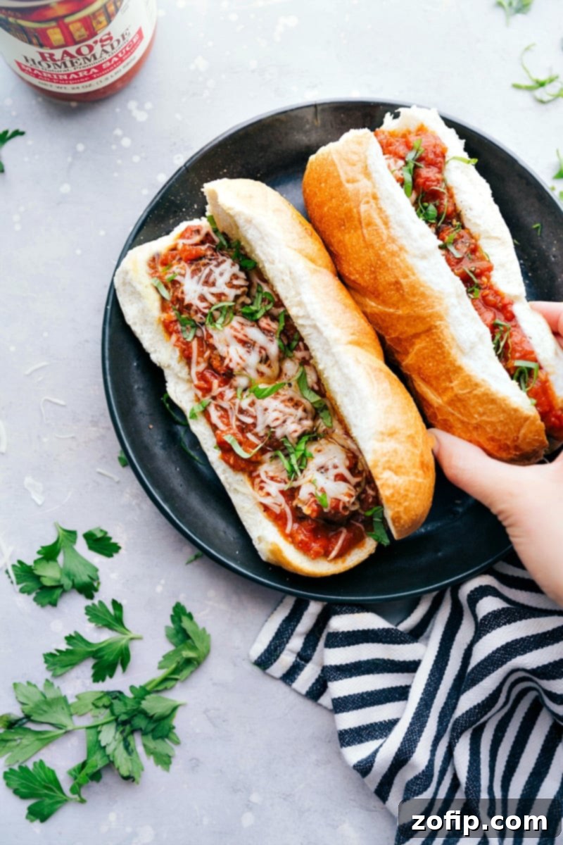 A plate filled with mouthwatering homemade meatball subs, where the golden-brown buns are overflowing with tender meatballs and rich marinara sauce, topped with melted provolone cheese and fresh parsley, all ready for a delightful meal.