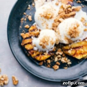 Caramelized Pineapple Slices 3 A delightful twist on a classic sundae, featuring grilled pineapple topped with vanilla ice cream and sprinkled nuts, combining warm and cold elements for a unique dessert experience.