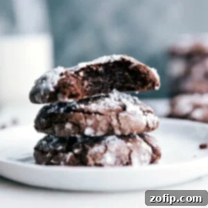 The finished chocolate crinkle cookie recipe, with cookies stacked and split to reveal their soft, gooey interiors.