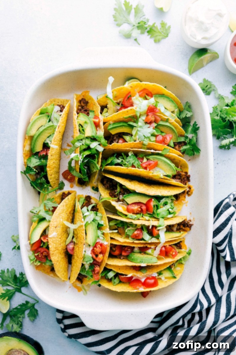 Perfect Meal: Freshly Baked Beef Tacos with a Variety of Toppings The delicious and finished beef taco recipe fresh out of the oven, topped with a variety of fresh ingredients like lettuce, tomatoes, and sour cream, creating the perfect meal.