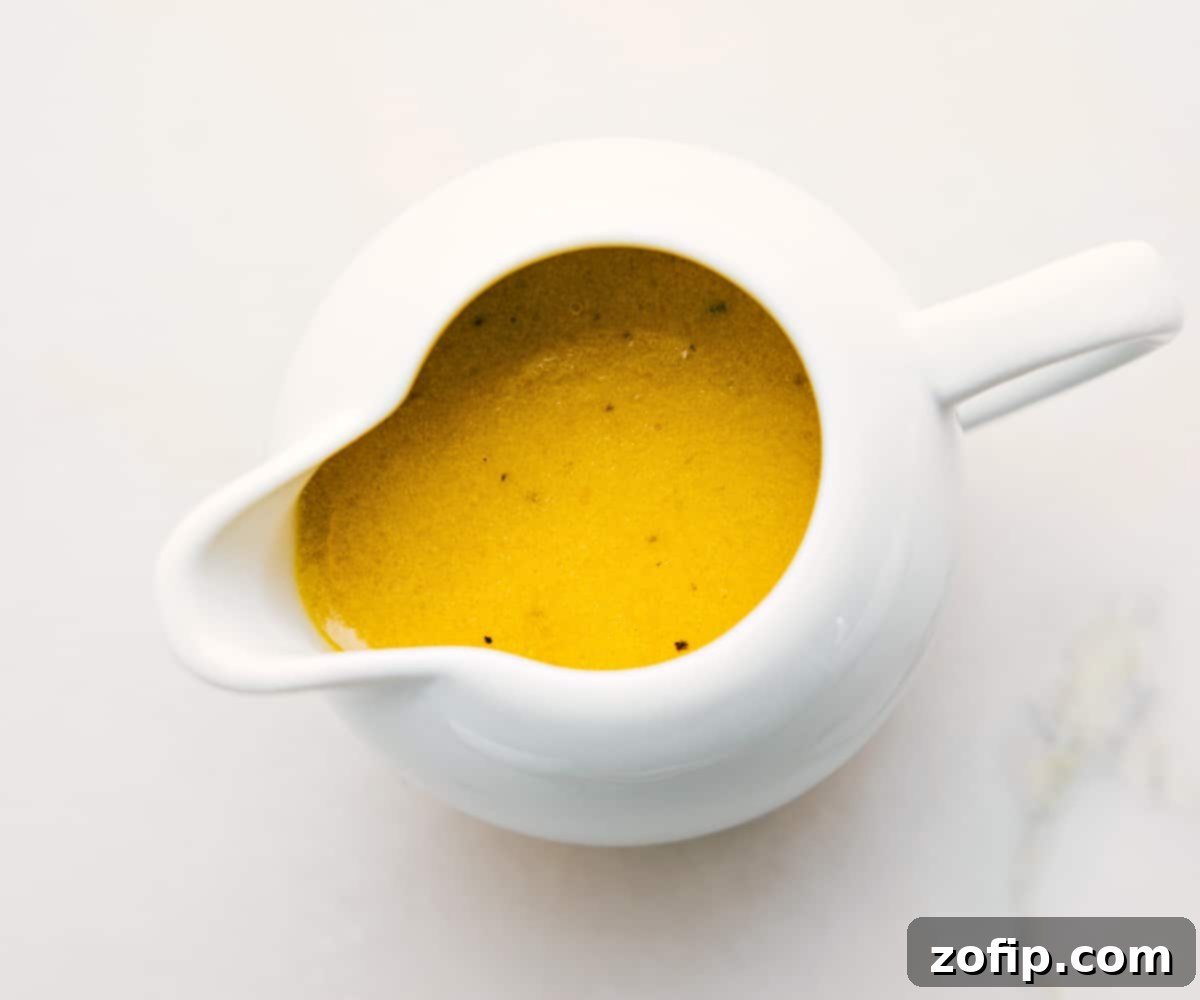 The vibrant homemade dressing for this avocado chicken salad, presented in a small container, ready to be drizzled generously over the fresh ingredients.