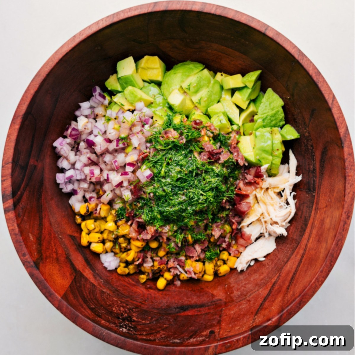 All the delicious ingredients for this chicken avocado salad, perfectly chopped and added to a large bowl, ready to be tossed together with the dressing.