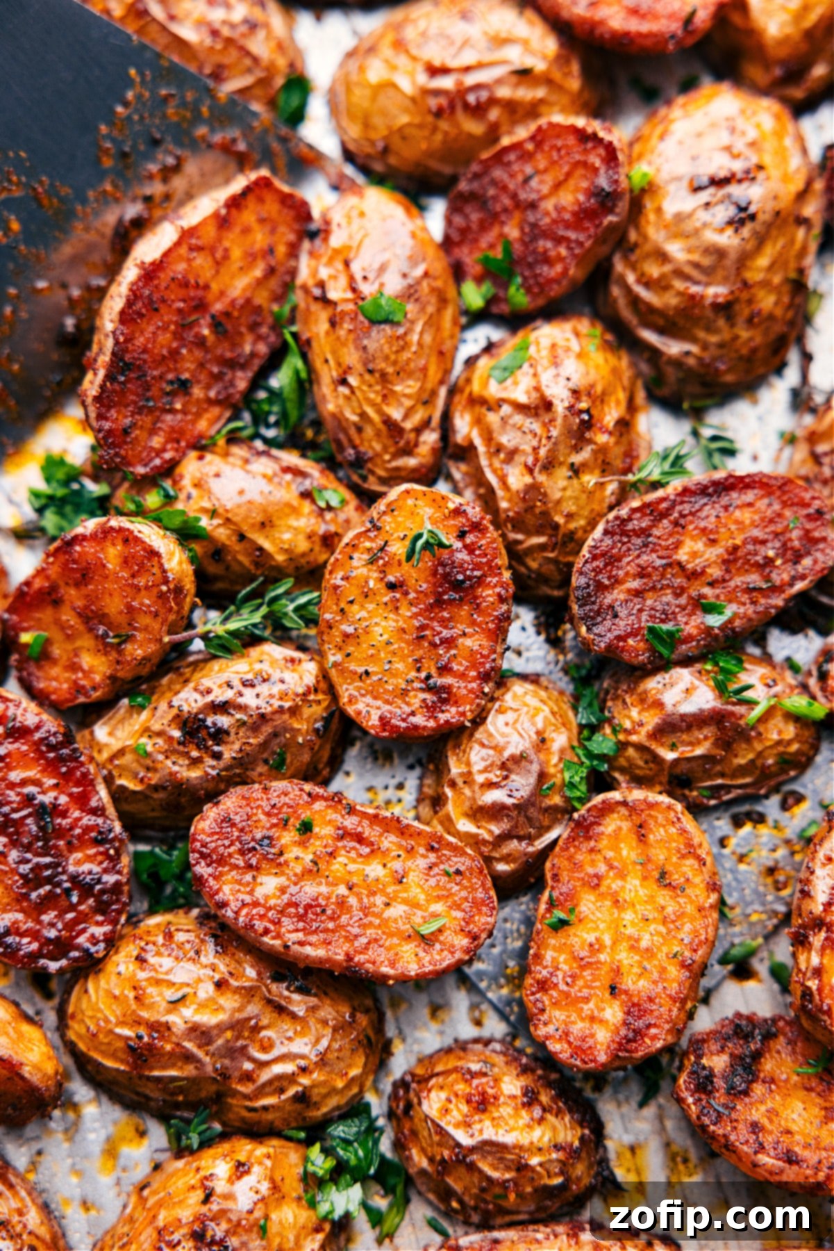 A baking tray filled with golden brown, perfectly roasted potatoes, ready to be served.