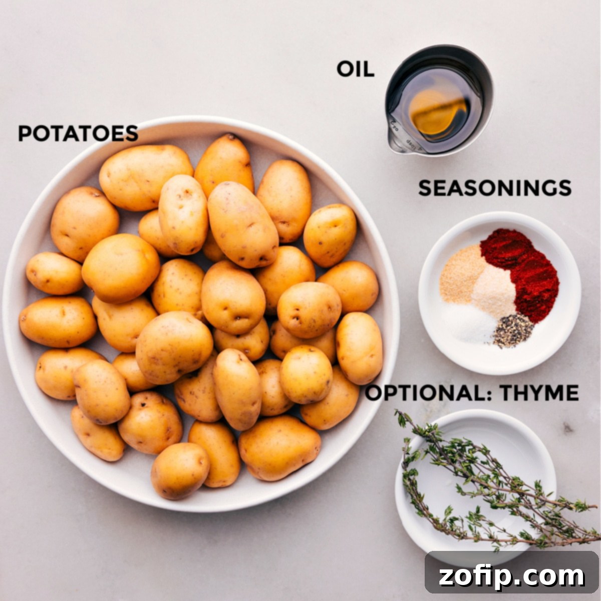 All the fresh ingredients for crispy roasted potatoes laid out on a cutting board, including baby gold potatoes, olive oil, and spices, ready for preparation.