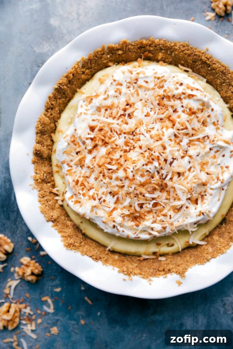An inviting overhead shot of a beautifully prepared Coconut Cream Pie, perfectly sliced and ready to be served, showcasing its creamy layers and toasted coconut topping.
