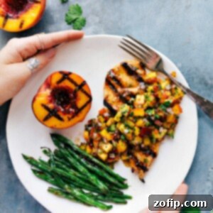 Sweet and Savory Peach Salsa Chicken 2 Peach salsa chicken served on a plate, accompanied by green beans and a freshly grilled peach on the side.