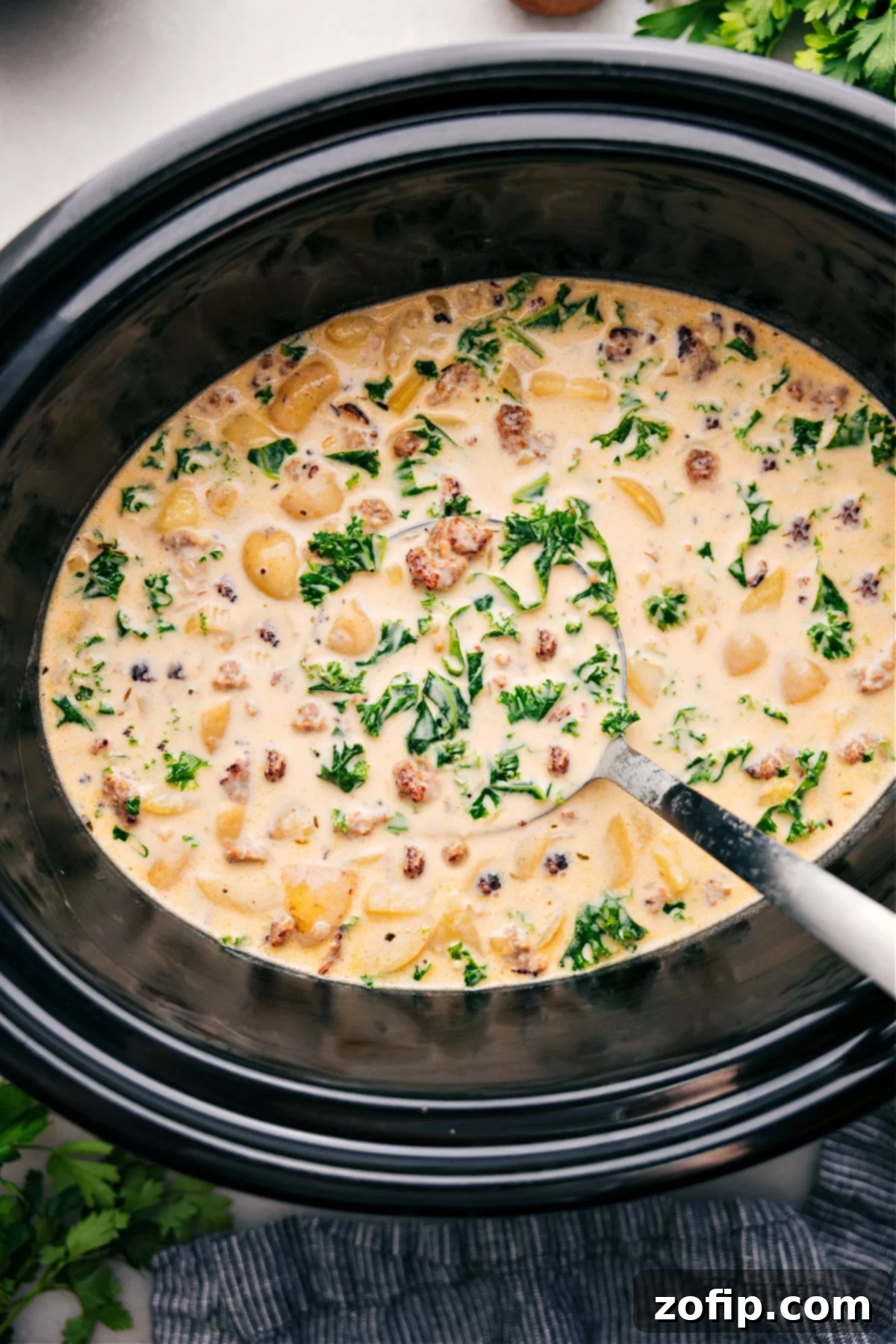 Hearty Zuppa Toscana Soup simmering in a crockpot, ready to be served.