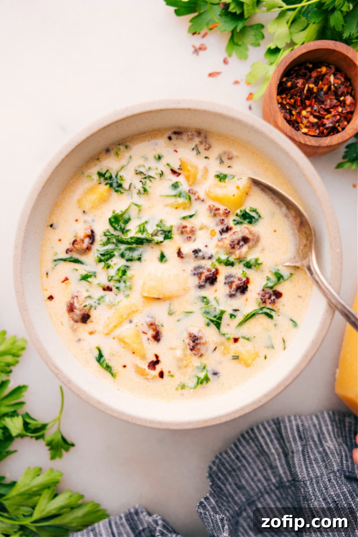 A large, inviting bowl of homemade Zuppa Toscana Soup, garnished with crispy bacon and fresh parsley, ready to be enjoyed.
