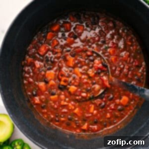 A close-up of a rich, comforting Sweet Potato Chili in a white bowl, ready to be served.