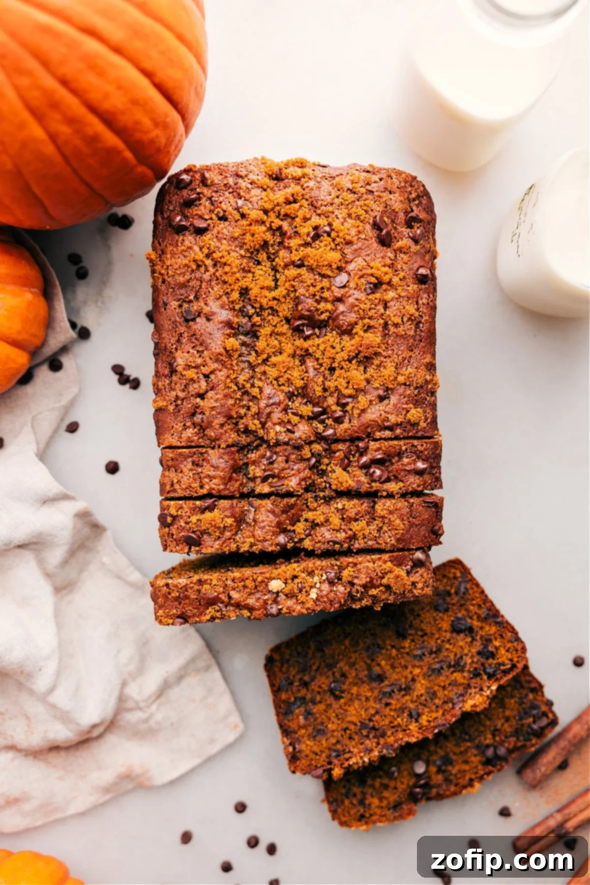 Delicious Sliced Pumpkin Chocolate Chip Bread: Moist and Fluffy Interior Ready to Enjoy Slices of moist chocolate chip pumpkin bread on a cutting board, revealing fluffy interior with chocolate chips.