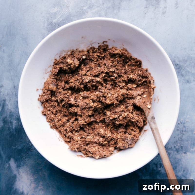 Perfectly prepared, rich chocolate energy bite dough waiting to be rolled into individual servings, showcasing its smooth and pliable texture.