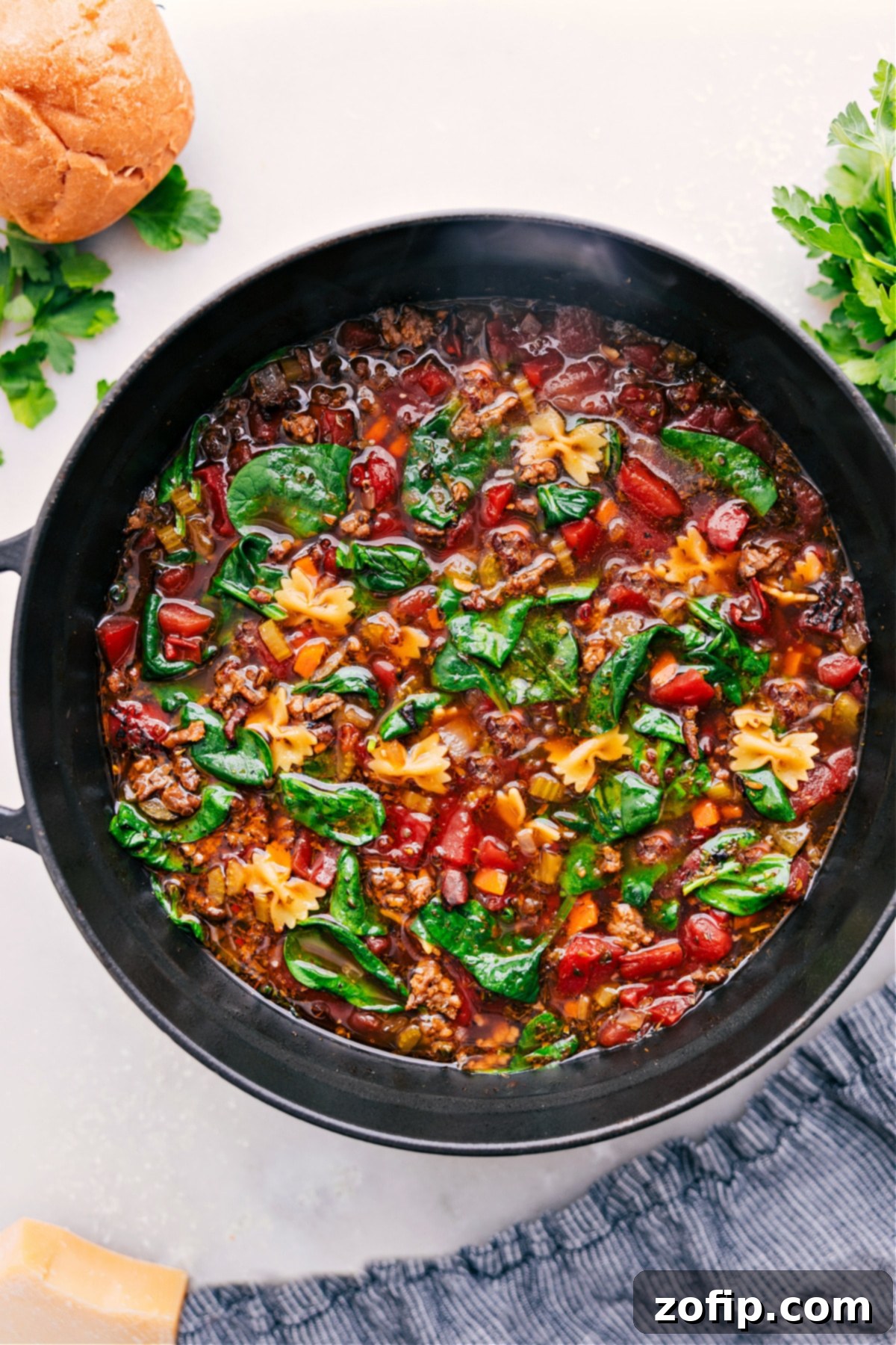 A steaming bowl of hearty Pasta Soup, ready to be enjoyed, showcasing a vibrant mix of Italian sausage, pasta, and spinach.