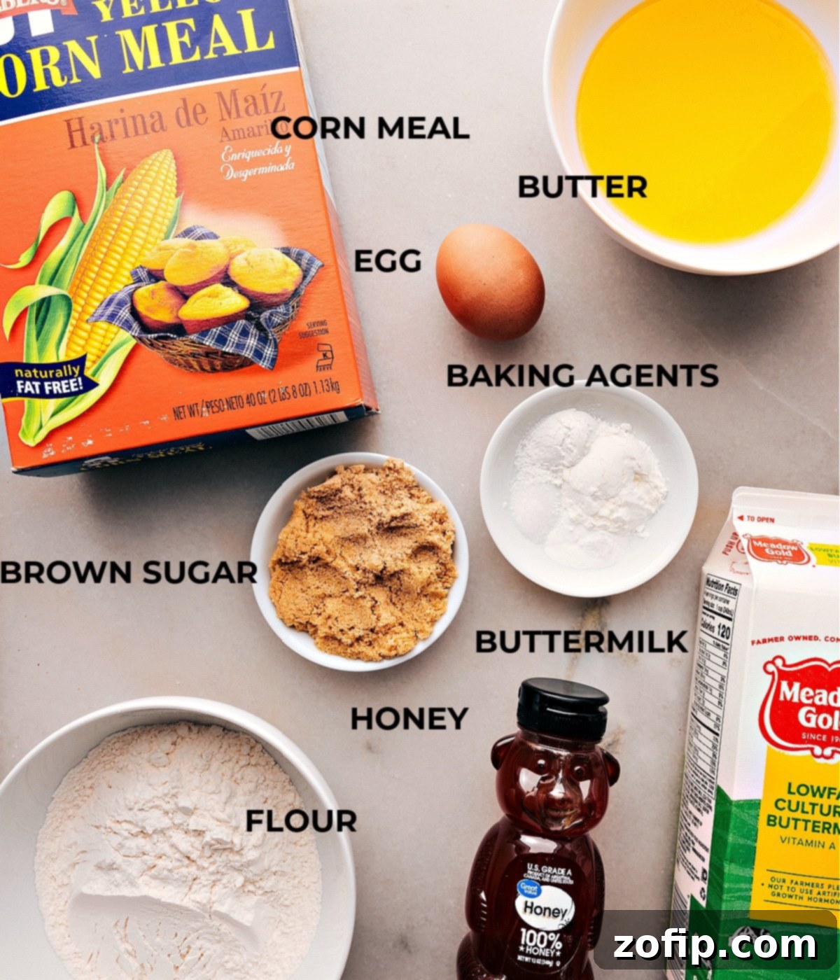 Ingredients used in cornbread recipe including butter, buttermilk, egg, honey, sugars, flour, cornmeal, baking agents, and cornstarch.