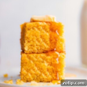 Stack of delicious and fluffy cornbread with honey and butter on a plate.