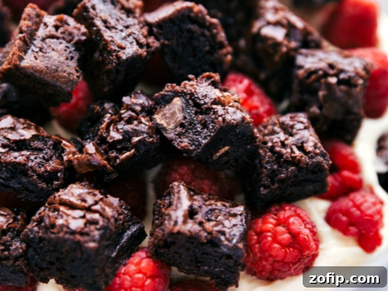 Decadent Brownie Trifle 2 The assembled trifle showcasing the beautifully arranged layers of fudgy brownies, creamy vanilla filling, and fresh berries, ready to be served.