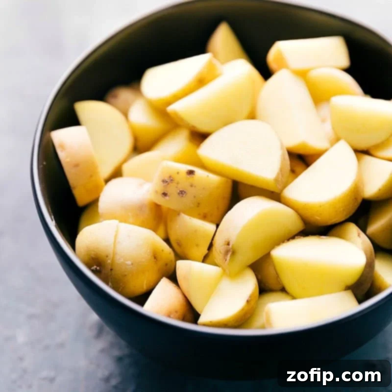 Close-up of perfectly prepared and diced baby gold potatoes, showcasing their smooth texture and even cuts, ready to be added to the Yellow Chicken Curry. The uniform size ensures even cooking and tender results.