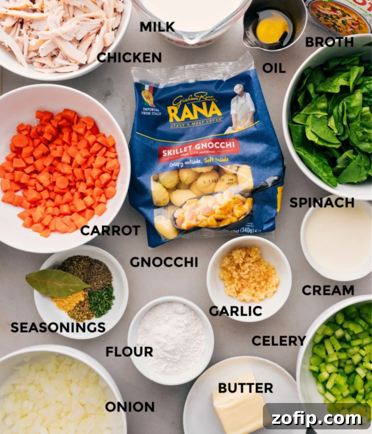All the essential ingredients for making delicious Chicken Gnocchi Soup, neatly prepped on a kitchen counter. This includes diced carrots, celery, and onion, minced garlic, a package of gnocchi, chicken broth, milk, heavy cream, olive oil, and various dried seasonings.