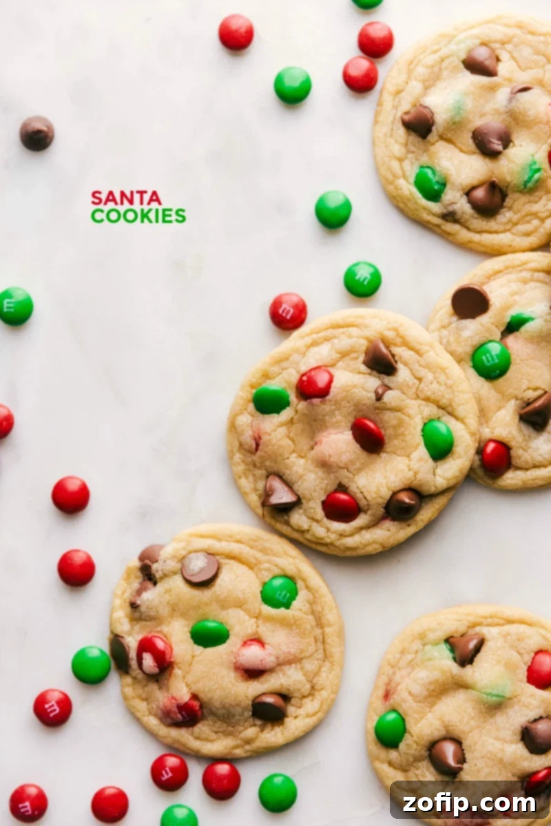 A charming collection of freshly baked Santa Cookies, beautifully adorned with vibrant red and green chocolate candies, placed on a festive holiday platter.