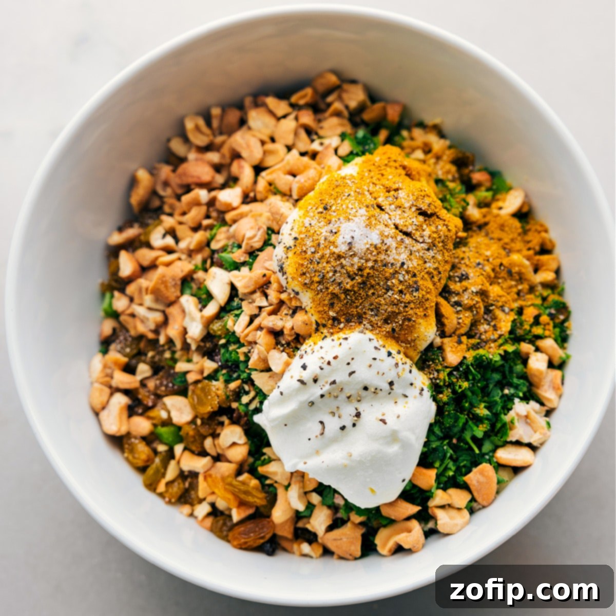 All the components for Curry Chicken Salad beautifully combined in a large bowl, ready to be gently mixed together to create a cohesive and flavorful dish.