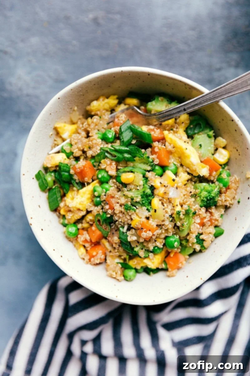 Bowl of quinoa fried rice with colorful vegetables, ready to serve.
