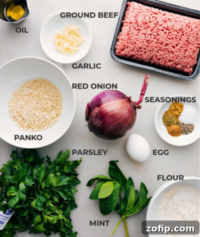 All fresh ingredients laid out on a wooden board for making Greek Meatballs, including ground beef, panko, herbs, and spices.