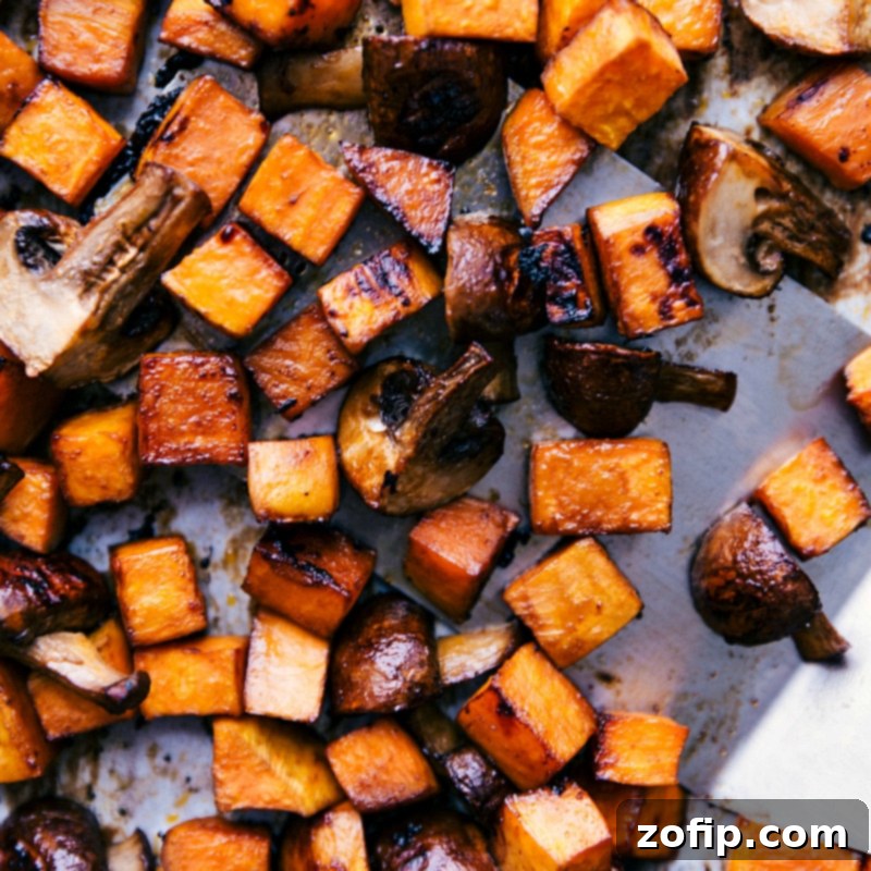 Freshly roasted sweet potatoes and cremini mushrooms, glistening with soy-Sriracha glaze, prepared for vegetarian lettuce wraps.