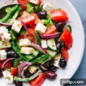 Fresh greek salad in a bowl with tomatoes, olives, feta cheese, and cucumbers.