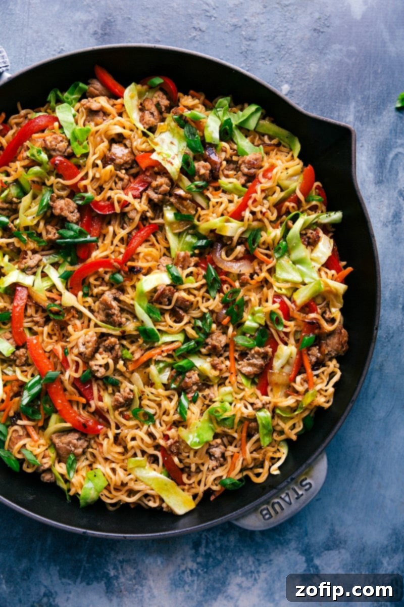 Completed Egg Roll Noodles in a large skillet, beautifully garnished with fresh green onions. A vibrant, delicious meal ready to be served.
