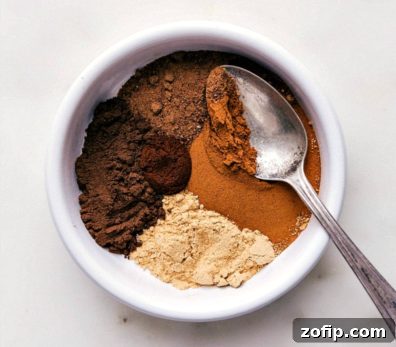 Assortment of ingredients for the pumpkin pie spice recipe, including cinnamon, nutmeg, and cloves.