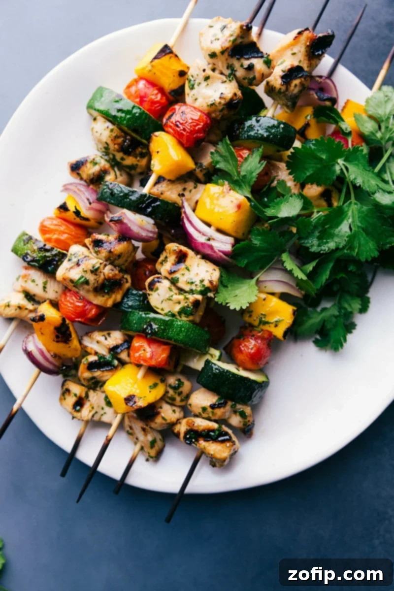 Gorgeous, vibrant chicken kabobs on a plate, grilled to perfection, and ready to eat, showcasing juicy chicken, caramelized mango, and colorful vegetables.