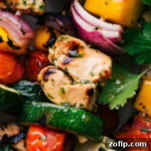 A plate of freshly grilled chicken kabobs with mango and vegetables, drizzled with a final touch of marinade, ready to be served and enjoyed.