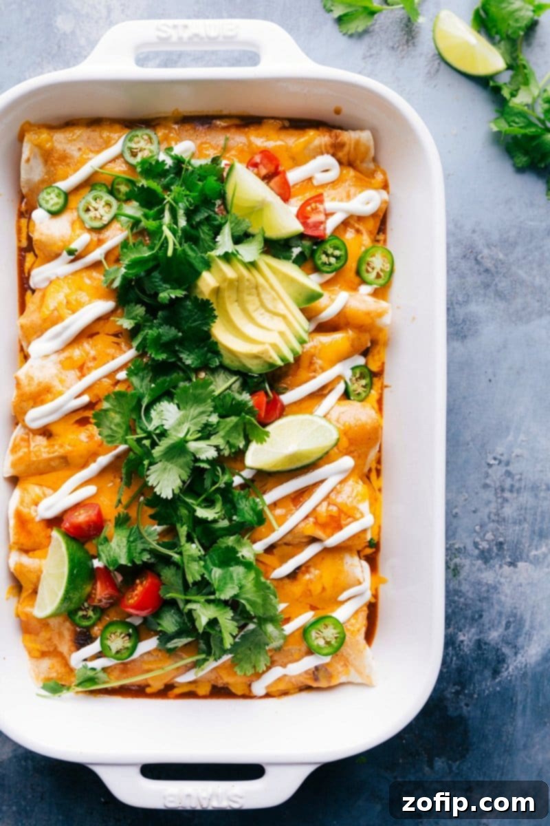 Perfectly baked Sweet Potato And Black Bean Enchiladas, golden brown and bubbly with melted cheese, fresh cilantro garnish.