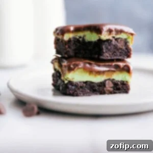 Stacked squares of mint brownies with a bite taken out of the top one.