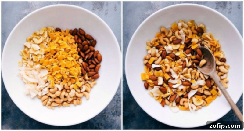 Assorted tropical trail mix ingredients, such as nuts, dried fruits, and coconut shavings, being combined in a large bowl.