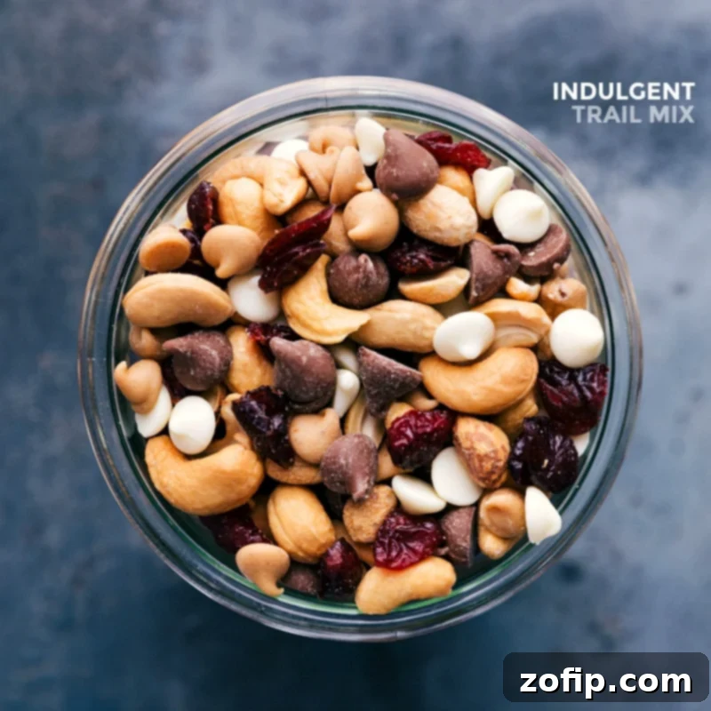 A glass jar filled with the finished, ready-to-eat indulgent trail mix snack, featuring a delightful blend of nuts, dried fruits, and other tasty morsels.