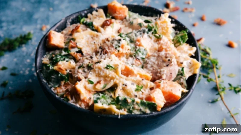 Image of Sweet Potato Pasta in a white bowl, garnished with fresh basil and chopped pecans