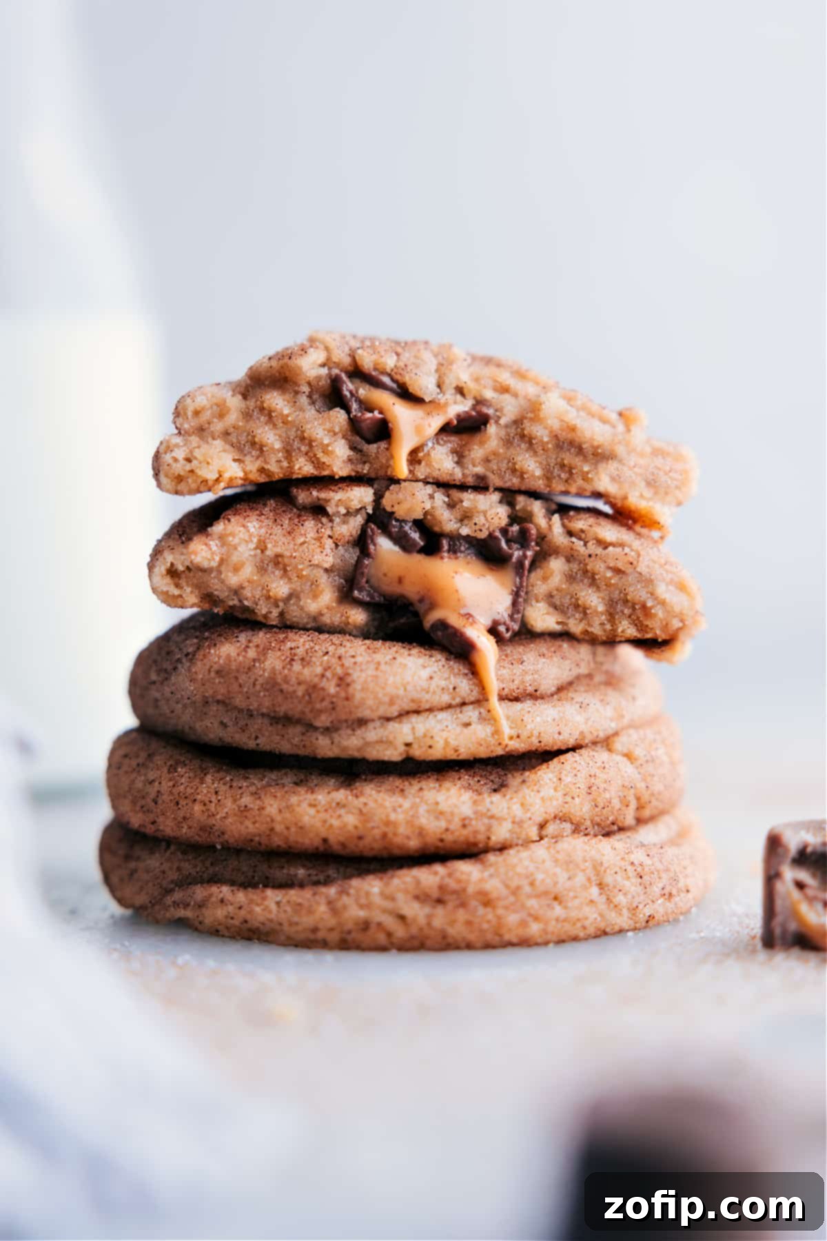 A stack of mouthwatering caramel snickerdoodles with centers oozing with melting caramel and chocolate, beautifully presented.