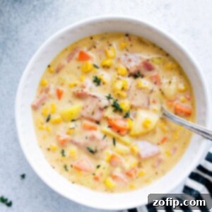 A hearty, inviting bowl of ham and potato soup, steaming and ready to be enjoyed.