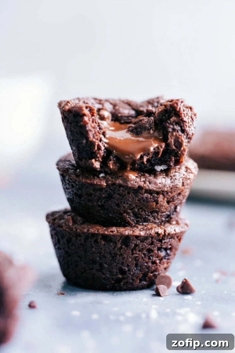 A stack of decadent brownie bites, each revealing a glistening, molten chocolate center, inviting you to take a bite. Perfectly baked and irresistibly rich.