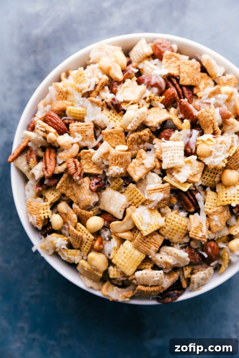 A large bowl brimming with a delicious and sweet Chex Mix, showcasing its golden, sticky coating and various ingredients, ready to be served.