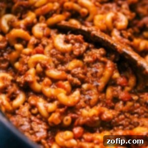 Freshly cooked American Goulash in a large skillet with a wooden spoon, ready to be served.