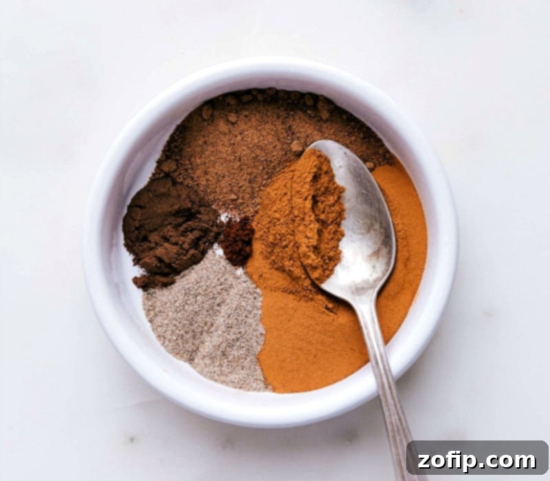 Bowl filled with ingredients for homemade apple pie spice recipe, ready for blending.