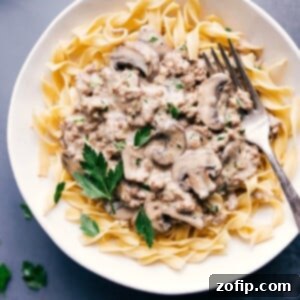Ground beef stroganoff served over tender egg noodles, garnished with fresh parsley.