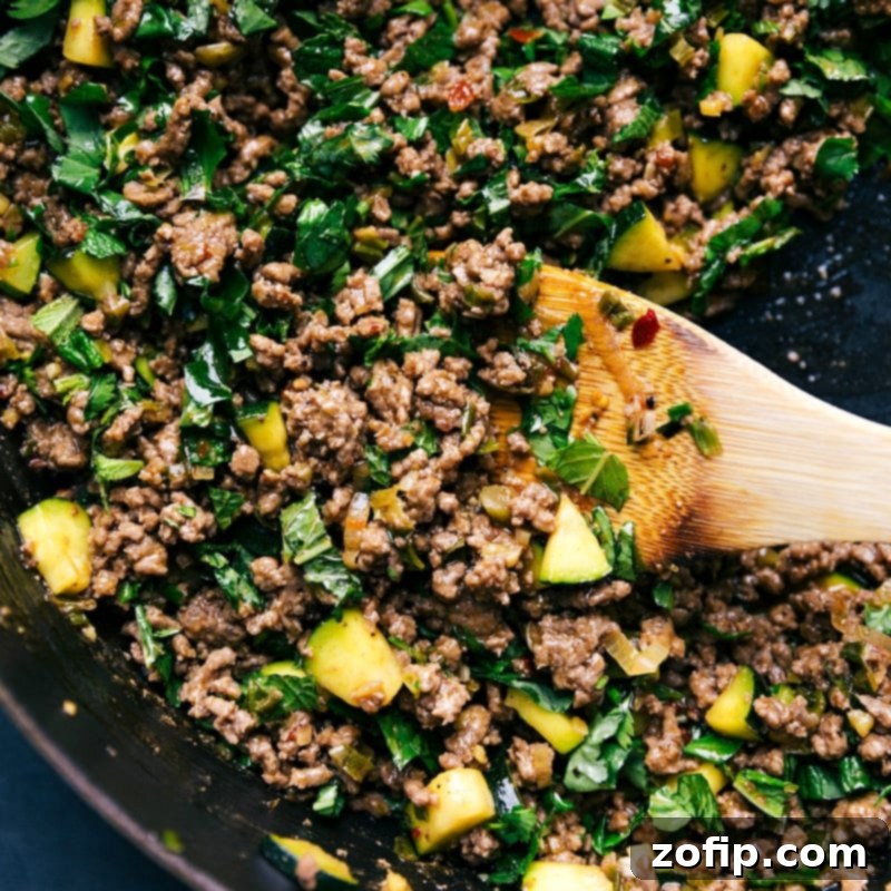 Serving Delicious Larb Beef Fresh from the Pan A wooden spoon delicately serving a portion of the freshly prepared larb beef dish directly from the cooking pan.
