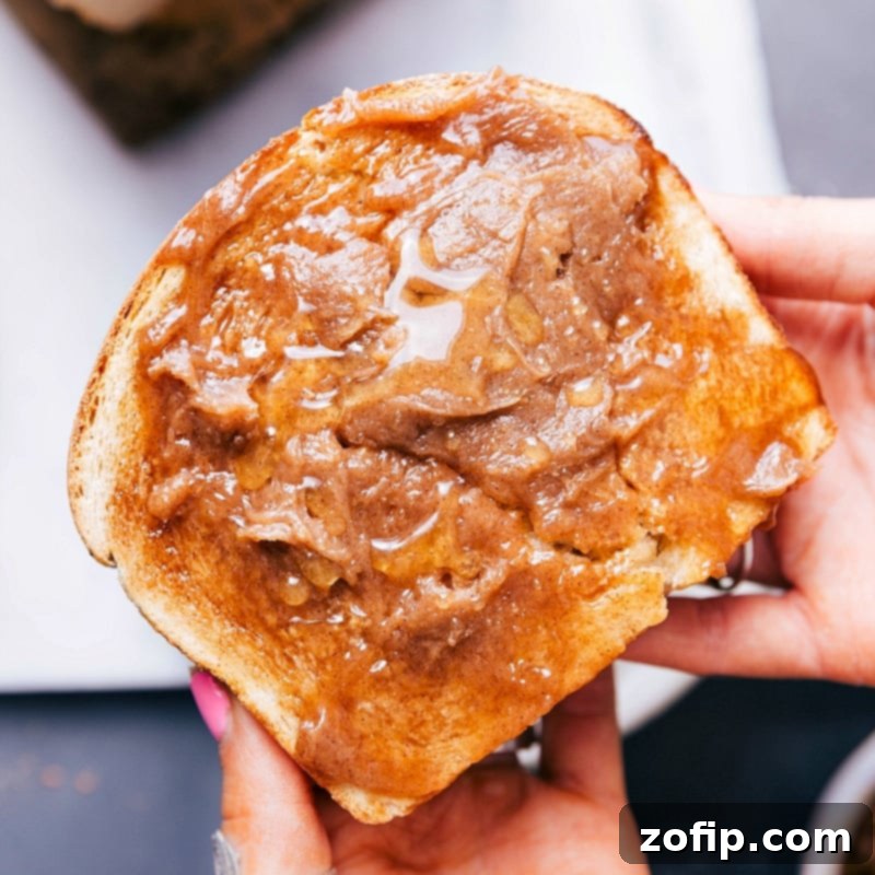 A delectable slice of honey whole wheat bread generously spread with creamy honey butter, ready to be savored.