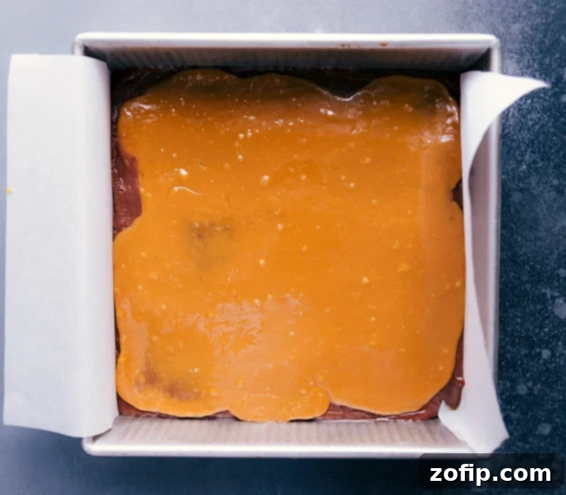 A pristine square of Microwave Fudge with a perfectly smooth, golden caramel layer spread evenly on top, ready to be cut.