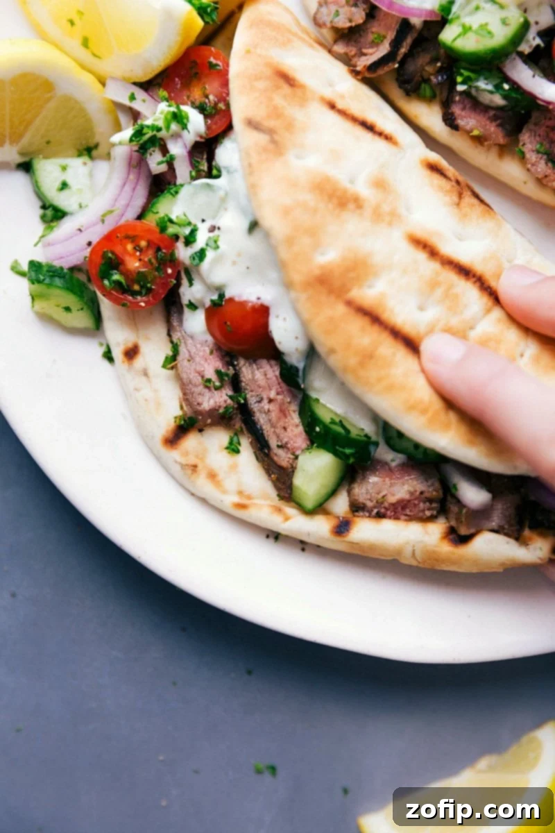 Steak gyros fully stuffed with succulent meat, fresh vegetables, and a delicious sauce, ready to be eaten.