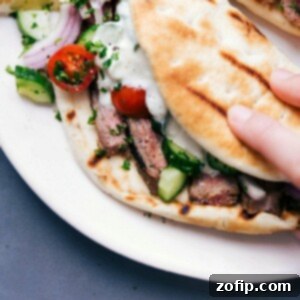 Steak gyros fully stuffed with succulent meat, fresh vegetables, and a delicious sauce, ready to be eaten.